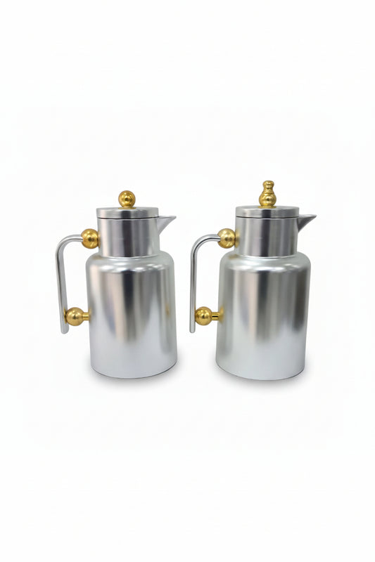 Two silver coffee pots with gold handles and knobs on a white background
